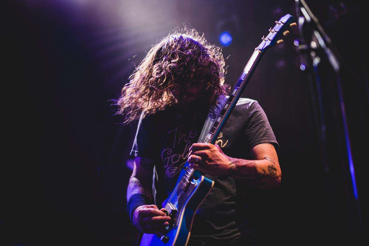 Image of a guitarist playing a guitar with intense expression