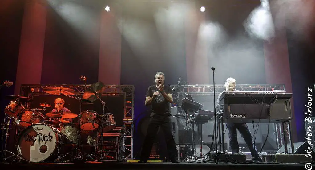 A mesmerizing image of the band Deep Purple performing live on stage, captivating the audience with their music.