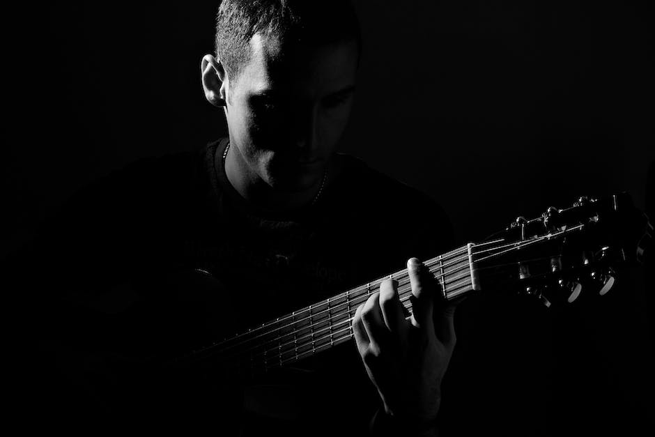 An image of a guitarist playing a guitar with passion and intensity