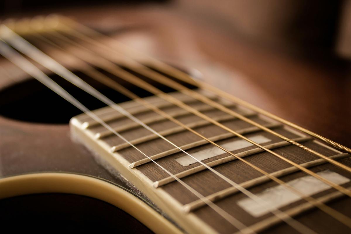 Illustration of a person reading and playing guitar tabs, with colorful tabs and musical notes floating in the air.