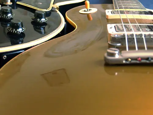 A vintage Gibson Goldtop electric guitar, showcasing its metallic gold finish and elegant design.