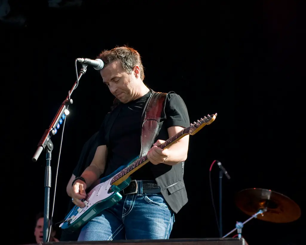 Colin James Playing A Guitar On A Stage